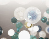 Close-up view of the Lasvit chandelier at Serenia Living, showing hand-blown glass spheres in white, turquoise and deep blue tones.